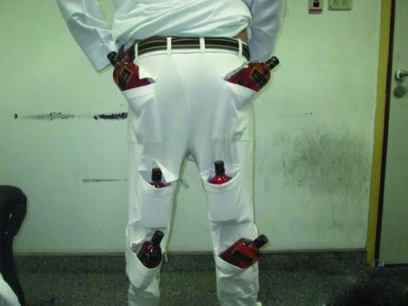 Smuggler hides 12 alcohol bottles in trouser, held Smuggler hides 12 alcohol bottles in trouser, held